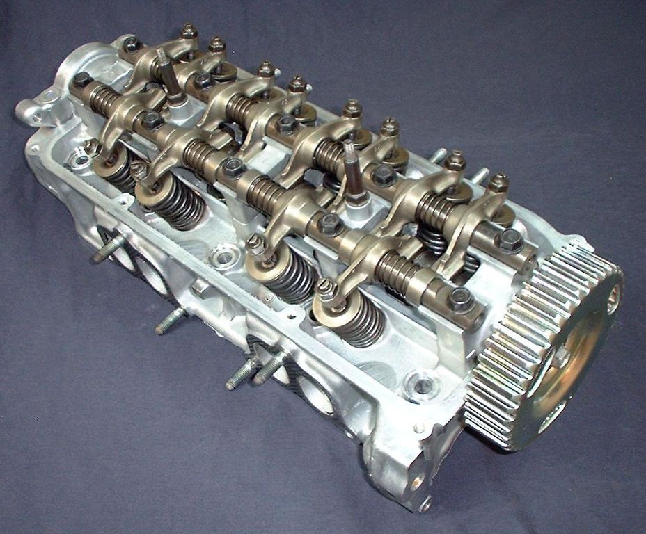 A cylinder head showing a single cam, rocker arms, valve springs, and other components. 